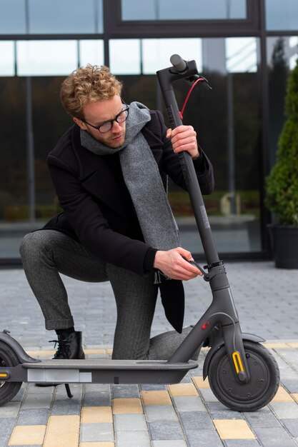 Macho adulto reparando su scooter eléctrico