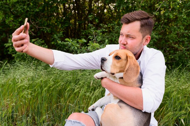 Macho adulto tomando una selfie con lindo perro