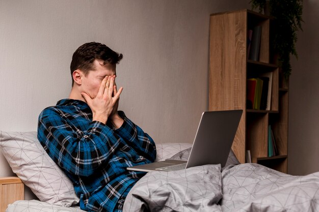 Foto gratuita macho adulto trabajando desde casa por la noche