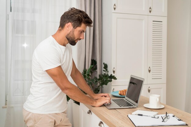 Macho adulto trabajando casualmente desde casa