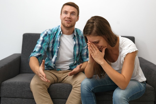 Foto gratuita macho joven lleno de alegría feliz con cerdas viendo la televisión en el sofá, ja