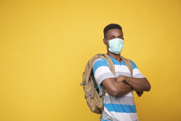 Macho joven con una mochila con una mascarilla