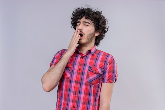 Foto gratuita macho joven pelo rizado aislado camisa colorida bostezo