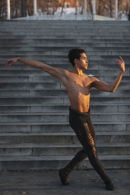 Macho joven realizando ballet al aire libre