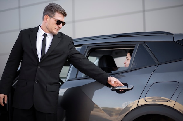 Macho joven siendo un conductor uber para una clienta