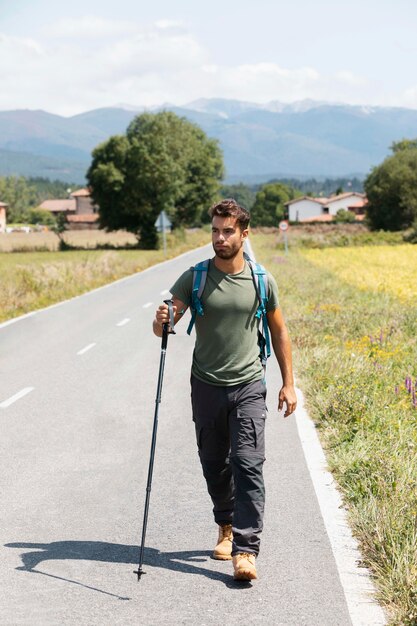 Macho joven viajero en Álava sosteniendo un bastón de senderismo