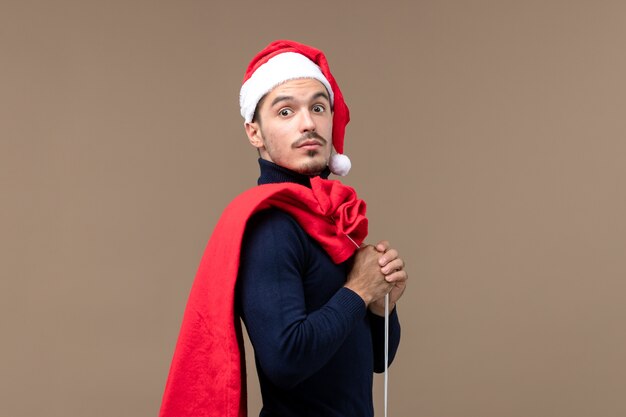 Macho joven de vista frontal con bolsa presente, emoción de vacaciones navidad