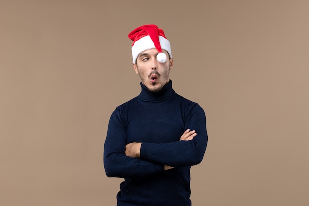 Macho joven de vista frontal con gorro rojo de navidad, vacaciones de navidad