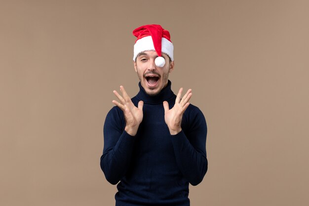 Macho joven de vista frontal con gorro rojo de navidad, vacaciones de navidad