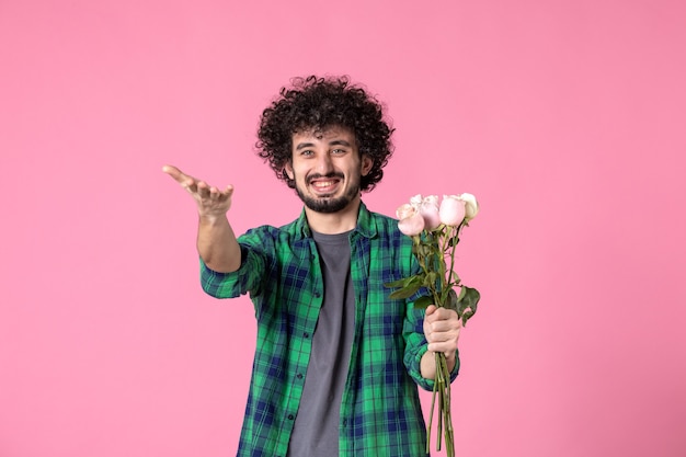 Macho joven de vista frontal con rosas rosadas en color rosa