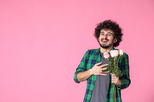 Macho joven de vista frontal con rosas rosadas en pinkr