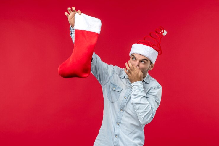 Foto gratuito macho joven de vista frontal sosteniendo un calcetín de navidad, vacaciones de navidad navidad