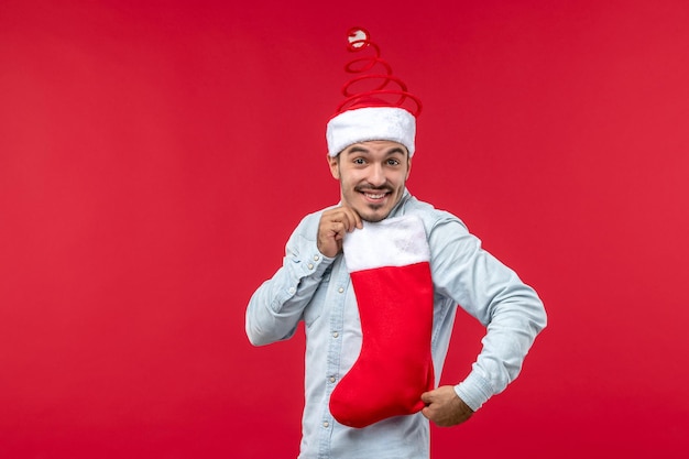 Foto gratuita macho joven de vista frontal sosteniendo un calcetín de navidad, vacaciones de navidad navidad