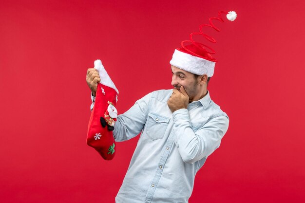 Macho joven de vista frontal sosteniendo un gran calcetín de Navidad, vacaciones de Navidad