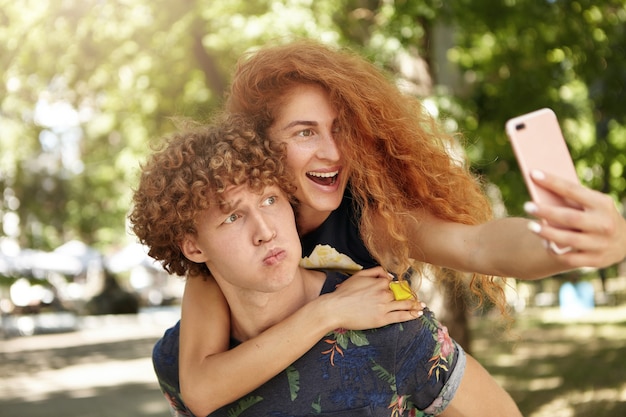 Macho reteniendo a su novia mientras mira smartphone