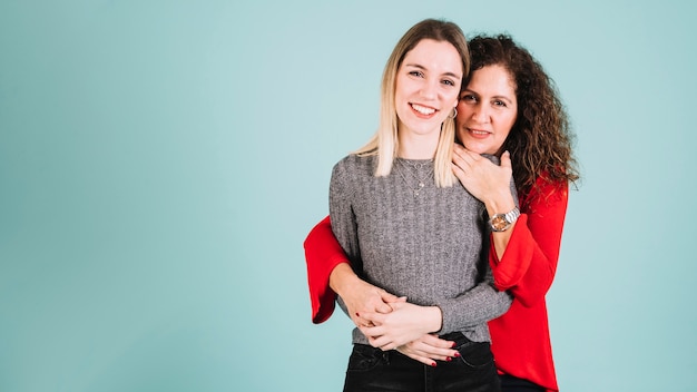 Foto gratuita madre abrazando a hija sonriente