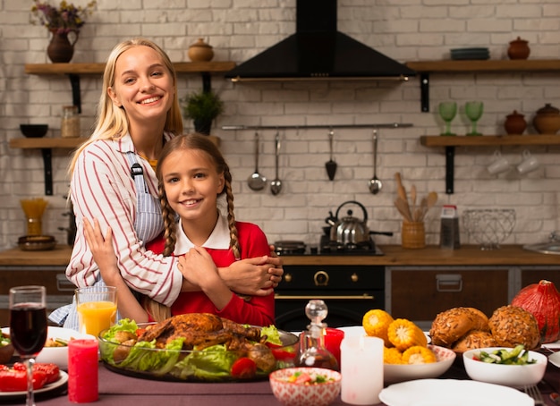 Madre abrazando a su hija en la cocina