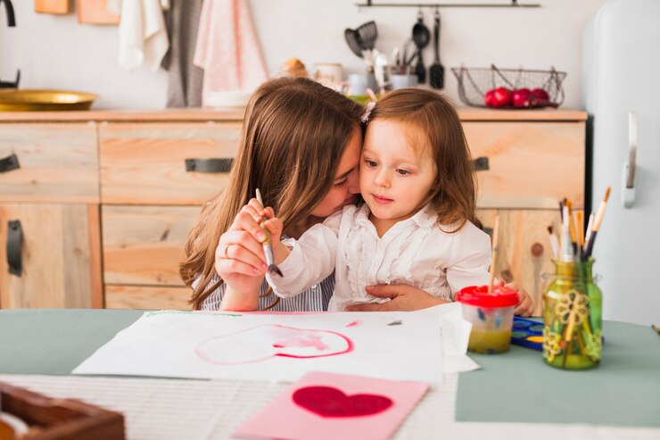 Foto gratuito madre abrazando a su hija mientras ella pinta corazón