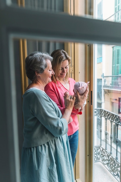 Madre y abuela con bebé por ventana