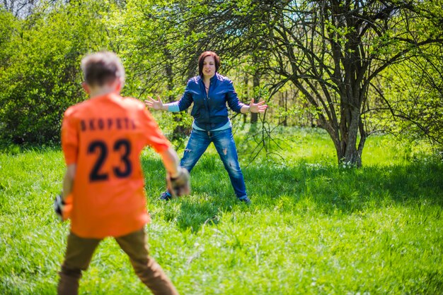 Madre activa jugando al fútbol con su hijo