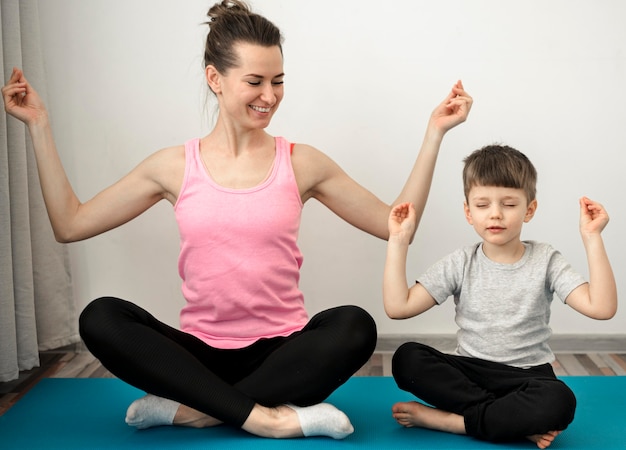 Madre activa practicando yoga con su hijo