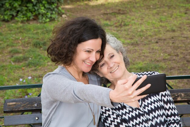 Madre alegre e hija tomando selfie