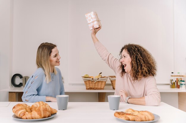 Madre alegre con regalo de hija