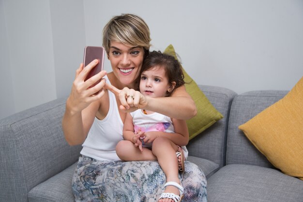 Madre alegre tomando selfie con su hija