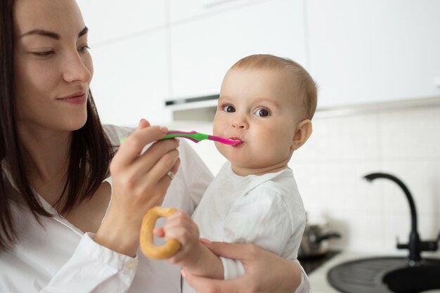 La madre alimenta al bebé con una cuchara.