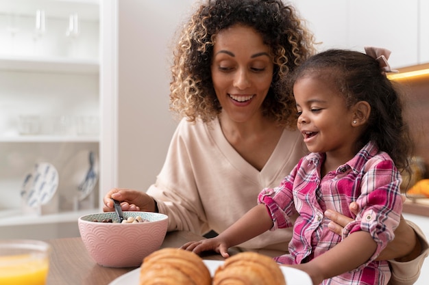 Foto gratuita madre alimentando a su hija en la cocina