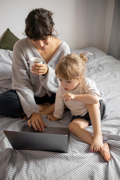 Foto gratuita madre de alto ángulo con niña en el dormitorio