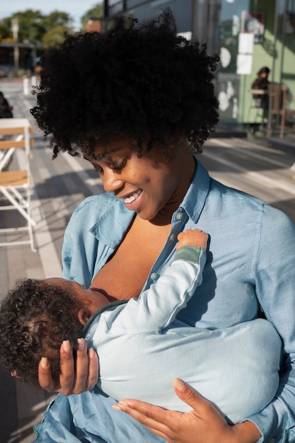 Foto gratuita madre amamantando al bebé al aire libre plano medio