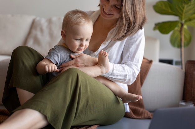 Madre amamantando a su hijo mientras trabaja