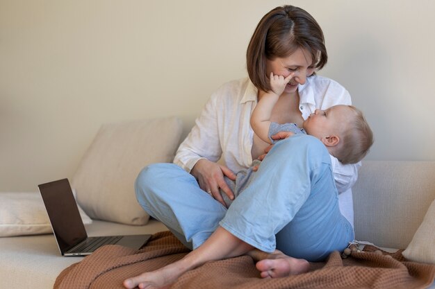 Madre amamantando a su hijo mientras trabaja