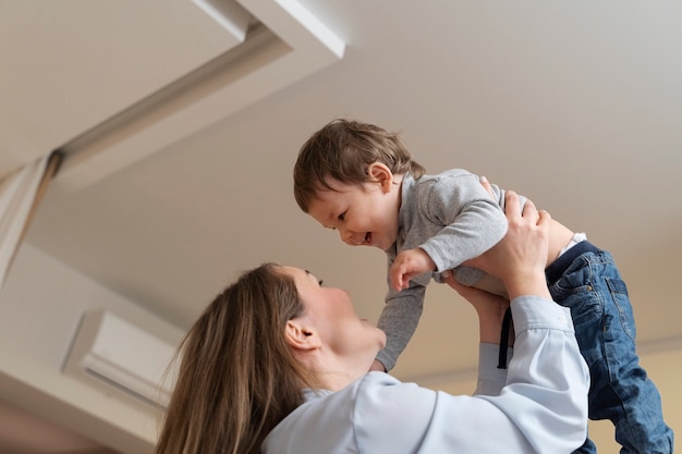 Madre de ángulo bajo sosteniendo a un niño