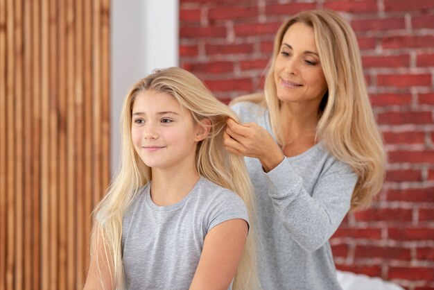 Madre arreglando hija cabello hermoso