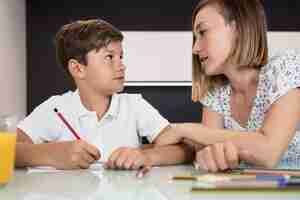 Foto gratuita madre ayudando a hijo con la tarea