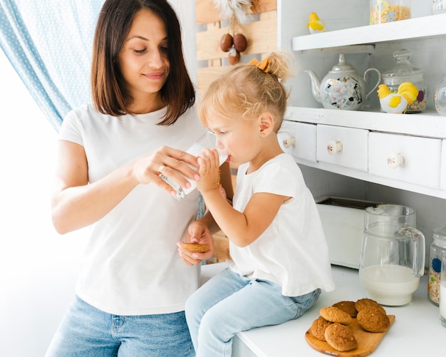 Madre ayudando a la niña a tomar leche