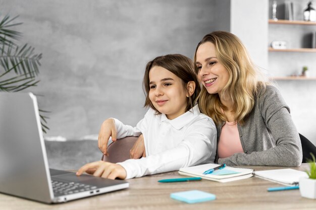 Madre ayudando a su hija a estudiar