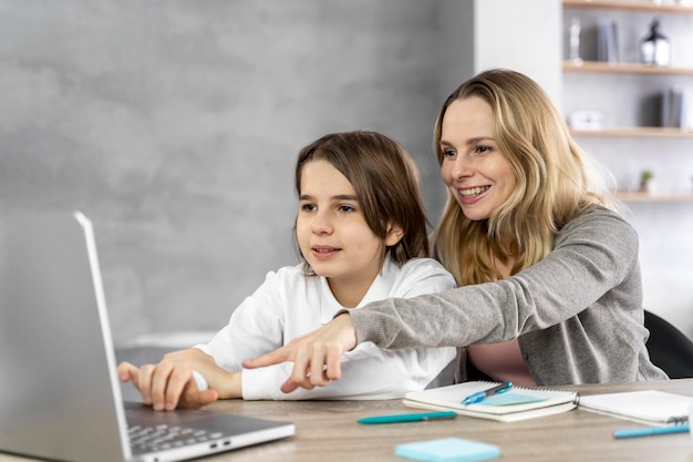 Madre ayudando a su hija a estudiar