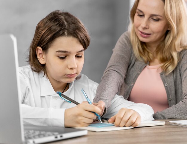 Madre ayudando a su hija a estudiar