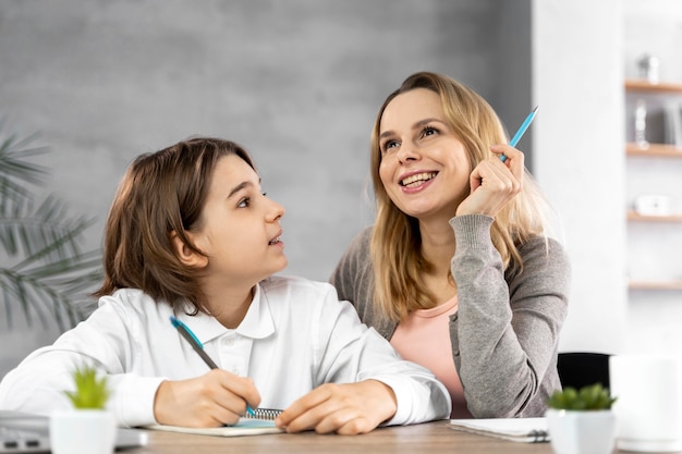 Foto gratuita madre ayudando a su hija a estudiar