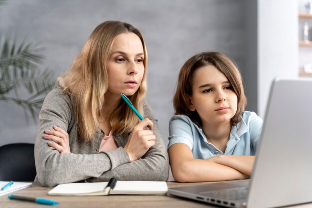 Madre ayudando a su hija a estudiar