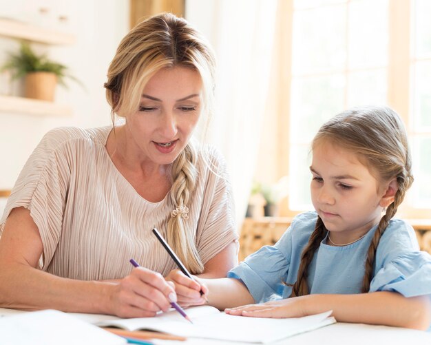 Madre ayudando a su hija con la tarea