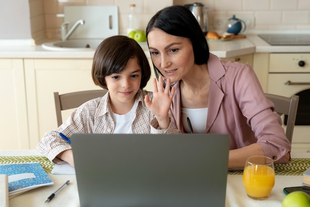 Madre ayudando a su hijo en una clase en línea