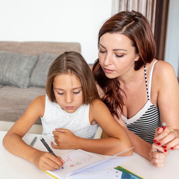 Madre ayudando con la tarea de su hija