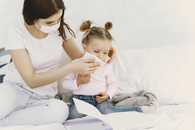 Madre y bebé en casa con máscaras médicas