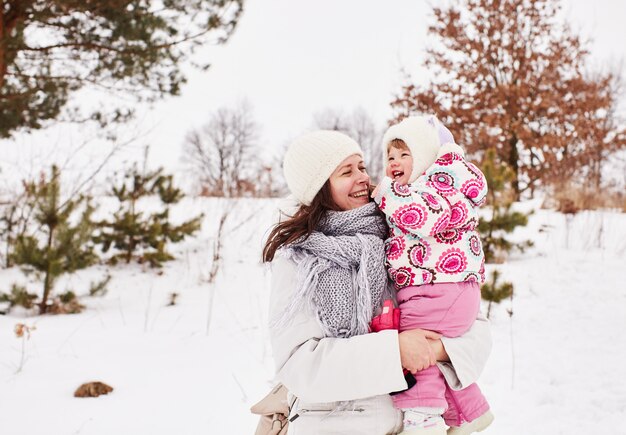 La madre y el bebé felices están sonriendo y abrazando