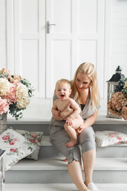 madre con bebé juega en estudio decorado flores