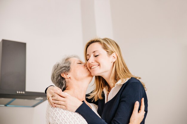 Madre besando hija en el día de la madre